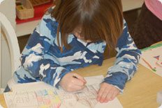 Child coloring at a table.
