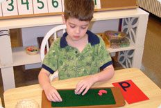 Child engaging in educational activity at table.