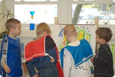 Children painting together in a classroom.